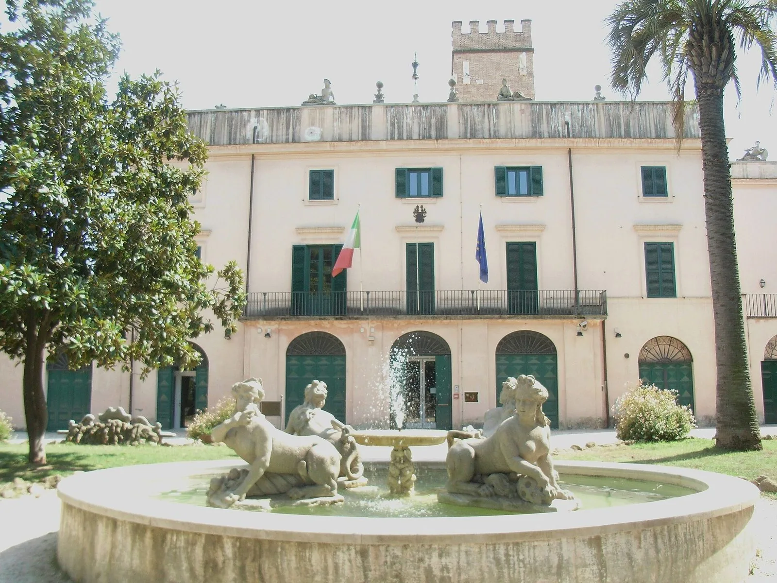 Il casino di Villa Sciarra a Roma con la fontana circondata da statue di figure fantastiche, una magnolia e una palma